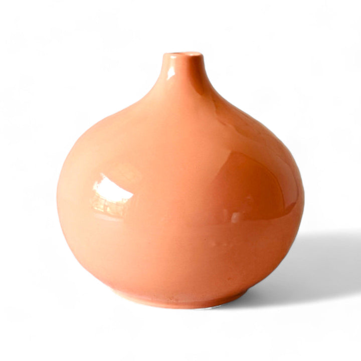 Display image of Glossy peach ceramic vase with a round bulbous shape and narrow neck.