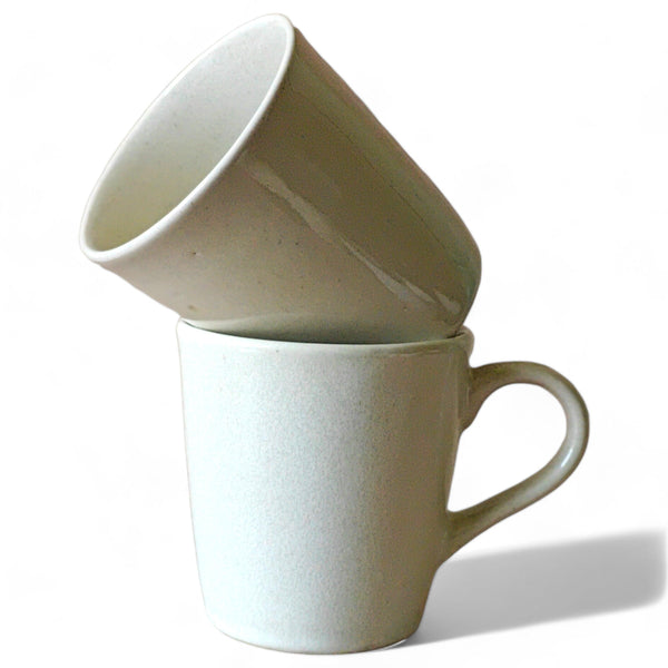 Display image of minimalist off-white ceramic mugs with smooth matte finish.