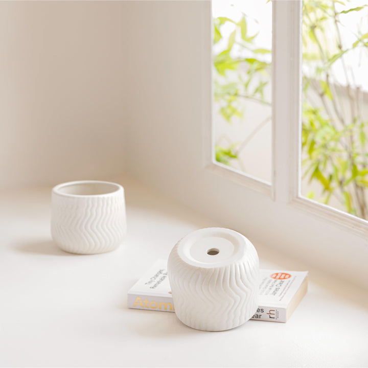 Display image of chalk white  ceramic planter with a wavy textured pattern and matte finish.