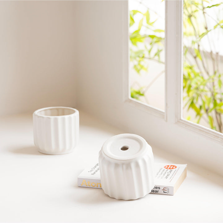 Display image of chalk white ceramic planter with a ribbed texture and glossy finish.