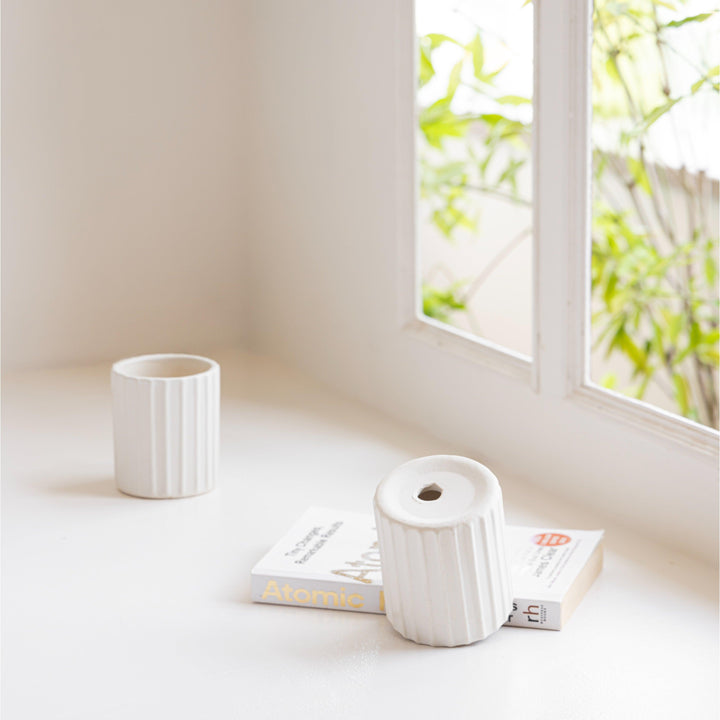 Display image of a white ribbed ceramic planter placed near a window with natural light.