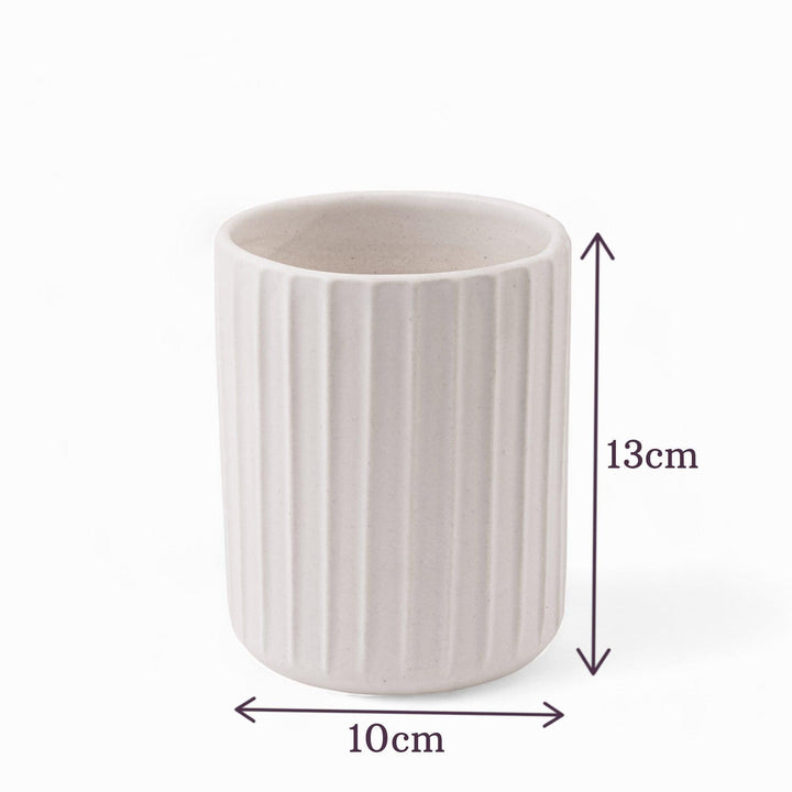 Display image of a white ribbed ceramic planter placed near a window with natural light.