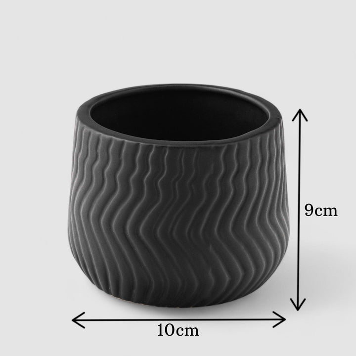 Display image of black ceramic planter with a wavy textured pattern and matte finish.