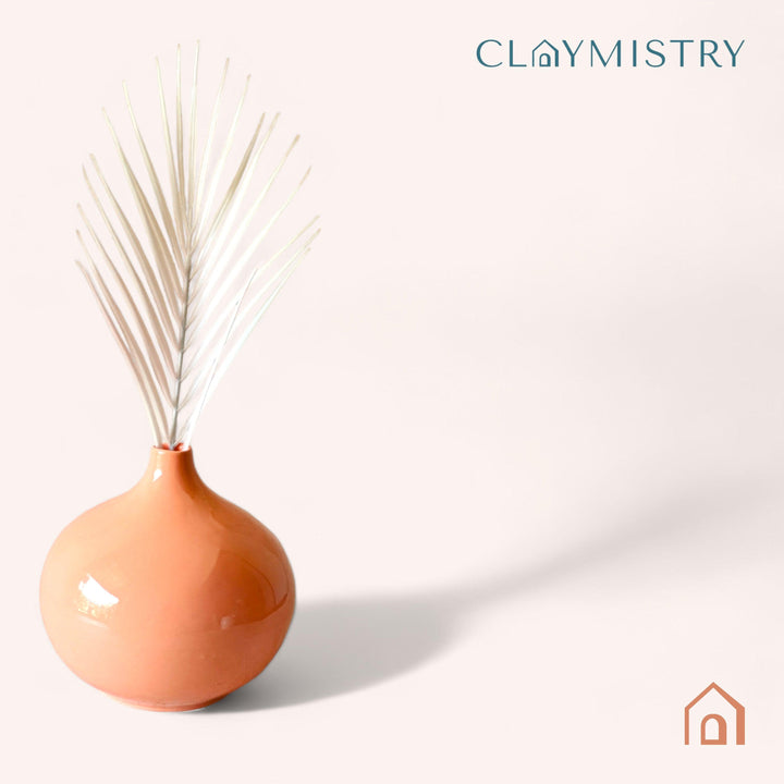 Display image of Glossy peach ceramic vase with a round bulbous shape and narrow neck.