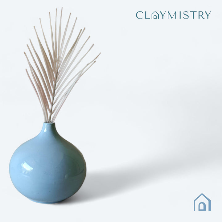 Display image of light blue ceramic vase with a round bulbous shape and narrow neck.