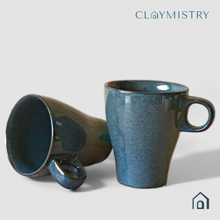 Display image of dark blue ceramic coffee mug with a glossy finish and ergonomic handle.