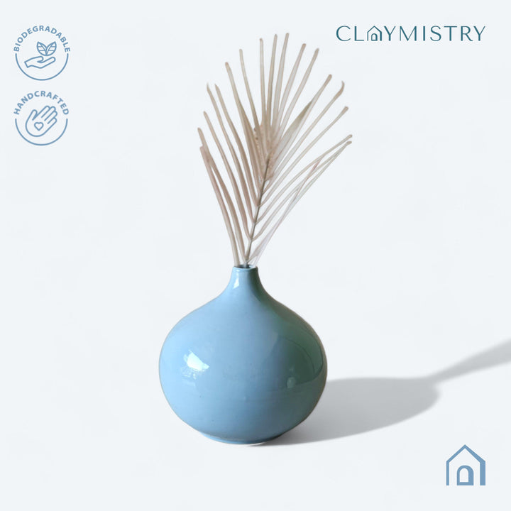 Display image of light blue ceramic vase with a round bulbous shape and narrow neck.