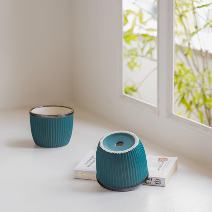 Display image of Handcrafted Top Trimmed ceramic planter with a ribbed texture in a sea green tone tone and a black rim, designed for indoor use.