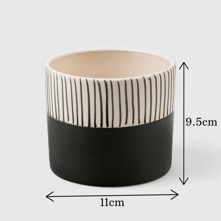 Display image of Black and white ceramic planter with vertical stripe detailing on the upper half and a smooth matte finish.