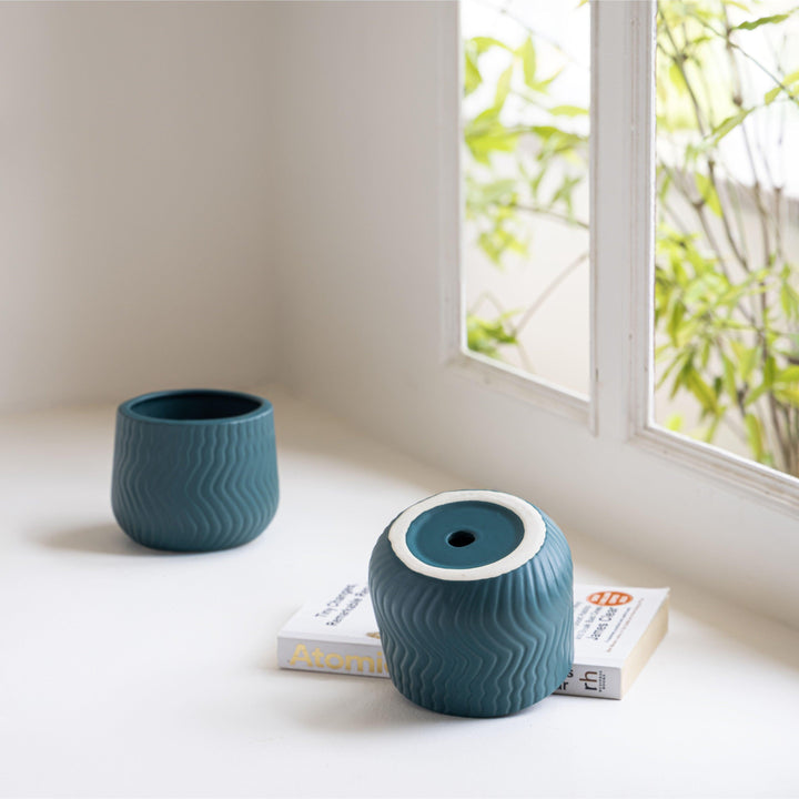 Display image of deep sea green  ceramic planter with a wavy textured pattern and matte finish.