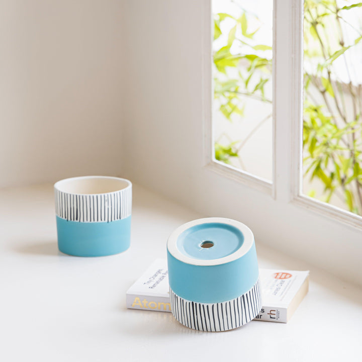 Display image of blue and white ceramic planter with vertical stripe detailing on the upper half and a smooth matte finish.