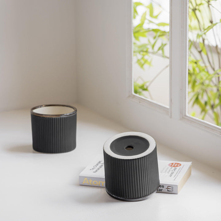 Display image of Black ceramic planter with a ribbed texture and brown rim, featuring a matte finish.