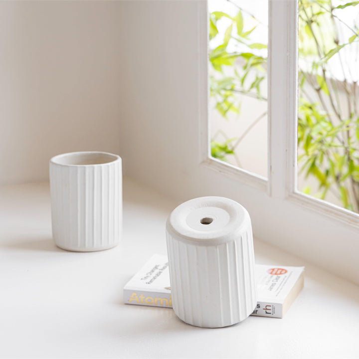 Display image of a white ribbed ceramic planter placed near a window with natural light.