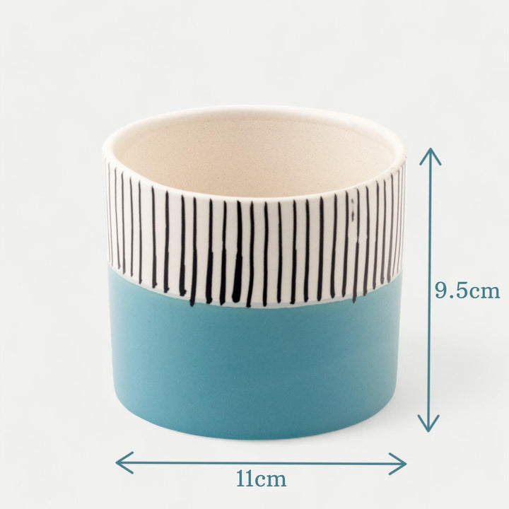 Display image of blue and white ceramic planter with vertical stripe detailing on the upper half and a smooth matte finish.